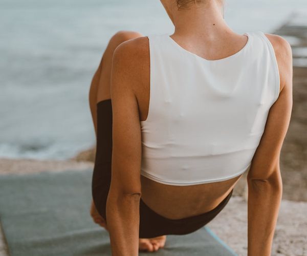 Person stretching gracefully during a yoga session at sunrise.
